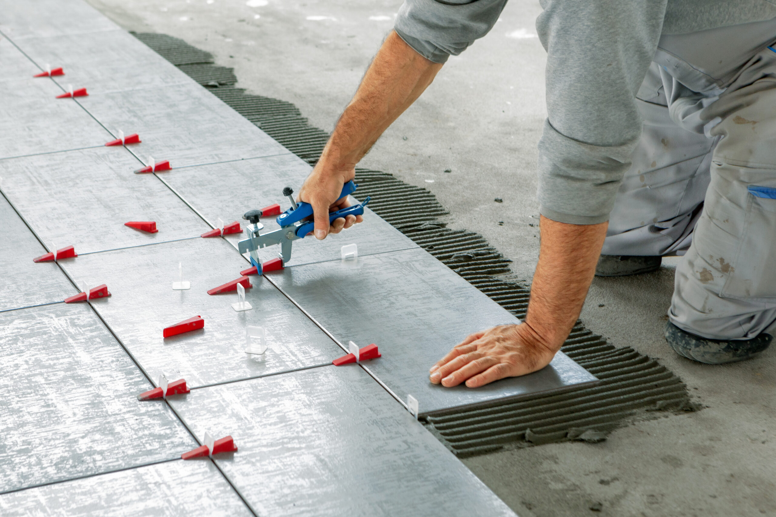 Ceramic,Tiles.,Tiler,Placing,Ceramic,Wall,Tile,In,Position,Over